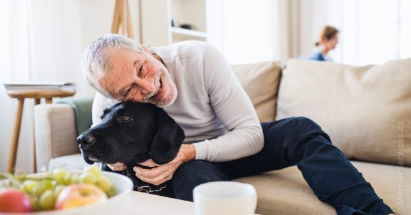 retired man hugging dog